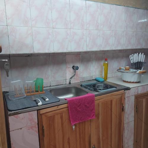 a kitchen with a sink and a counter top at Le séjour fruité in Ouidah