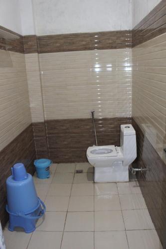 a bathroom with a toilet and a trash can at AK family Home Stay in Gaushala