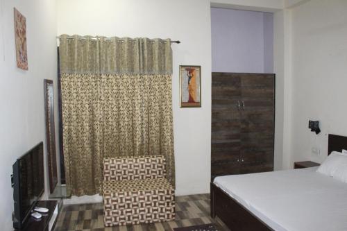 a bedroom with a bed and a shower curtain at AK family Home Stay in Gaushala