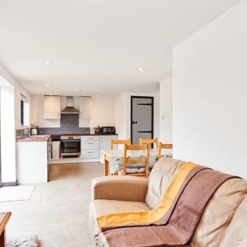a living room with a couch and a kitchen at Farm stay close to Shakespeare's Stratford-upon-Avon in Stratford-upon-Avon