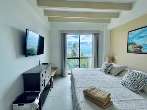 a bedroom with a bed and a flat screen tv at Bay Point- Ocean View Apartments by NIDHO PROPERTIES in San Andrés