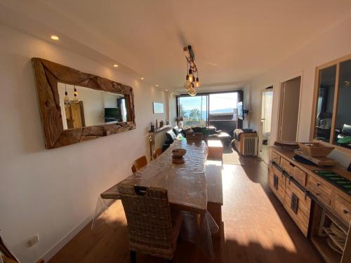 een eetkamer met een lange tafel en een spiegel bij Appartement 8 personnes 3 chambres 1 750 m altitude in Chamrousse