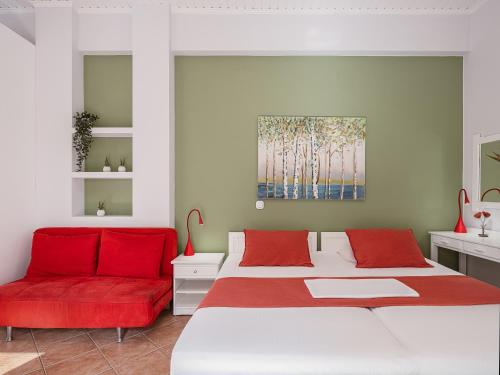 a bedroom with two beds and a red couch at Elena Seafront Luxury Apartments in Almirida