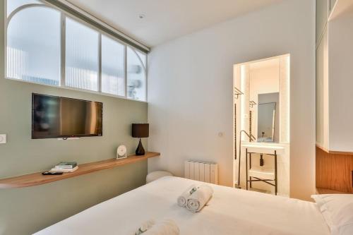 - une chambre avec 2 lits et une télévision murale dans l'établissement Luxe et Architecture au Centre de Paris pour 6 Pers, à Paris