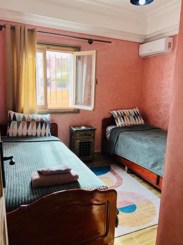 a bedroom with two beds and a window at Julie's AIRPORT Apartment in Marrakech