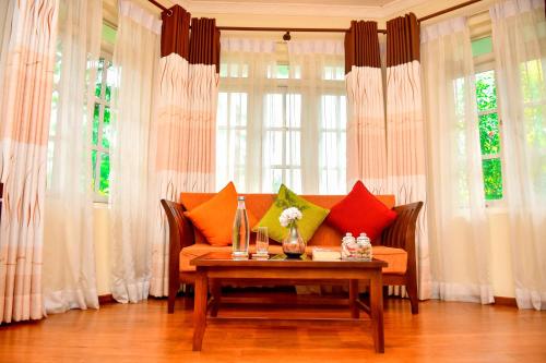 a living room with a couch and a table with pillows at Tea Queens Bungalow in Hatton