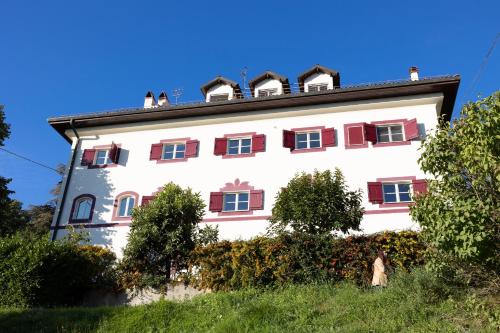 a large white building with red shuttered windows at Large villa for 20 guests on large estate with private pool and tennis court Big conference room with facilities VILLAITALY EU in Cairo Montenotte