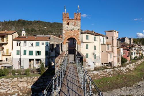 a suspension bridge over a river in a city at Large villa for 20 guests on large estate with private pool and tennis court Big conference room with facilities VILLAITALY EU in Cairo Montenotte