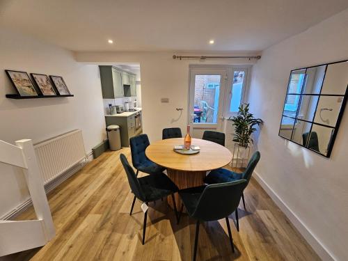 een eetkamer en woonkamer met een tafel en stoelen bij Pretty City Centre Cottage in Hackington