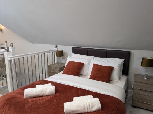 a bedroom with a large bed with two towels on it at Village Life, Beautiful Studio Apartment in Wombourn