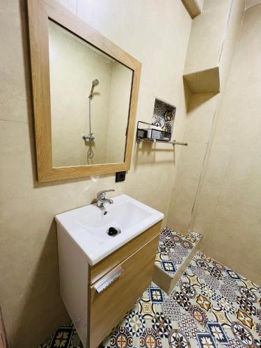 a bathroom with a sink and a mirror at Julie's AIRPORT Apartment in Marrakech