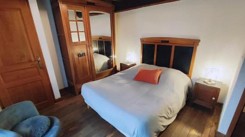 a bedroom with a bed with an orange pillow on it at La brasserie in Chooz