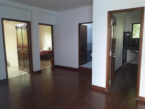a room with two doors and a room with a wooden floor at The Bodhgaya Guest House in Bodh Gaya