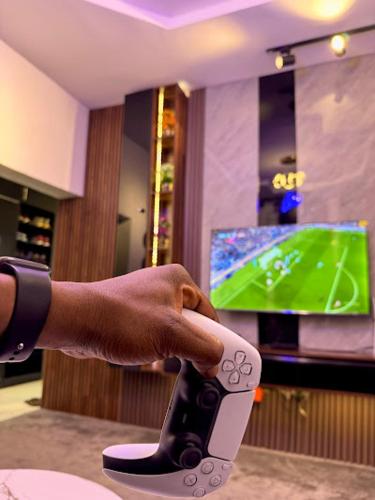 a person holding a wii remote in front of a tv at Comfortable 1 bedroom Apartment in Garki