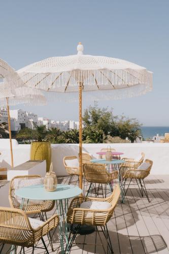 a patio with tables and chairs and an umbrella at Dreamsea Boutique Experience in Moya