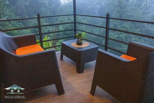 a balcony with two chairs and a table with a view at Valle Arenal in Fortuna