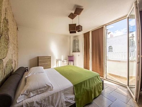 a bedroom with a bed and a large window at Martine Dimore Storiche di Puglia in Martina Franca