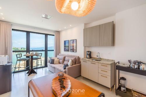 a kitchen and living room with a view of the ocean at MHF II - Apts Variados em Prédio com Vista para o Mar em Itapema in Itapema