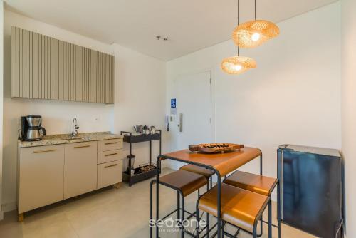 a kitchen with a table and chairs in a room at MHF II - Apts Variados em Prédio com Vista para o Mar em Itapema in Itapema