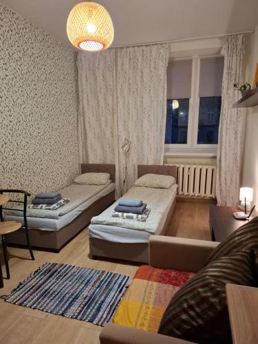 uma sala de estar com duas camas e um sofá em Night Host Krakowska 3 przy Rynku free parking em Bytom