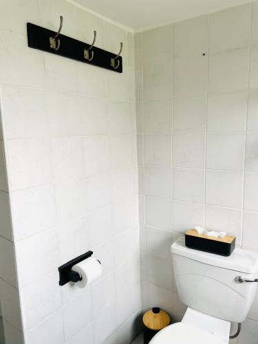a white bathroom with a toilet with a black box on it at Atlantis Luxe escape Unit 25 in Uvongo Beach