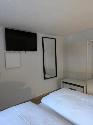 a bedroom with two beds and a flat screen tv at Haus Walch in Pettneu am Arlberg