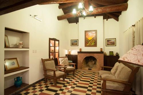 a living room with a fireplace and chairs at Casa Grande Hotel Tilcara in Tilcara
