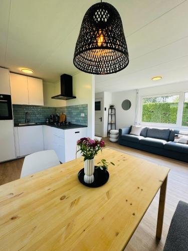 a kitchen and living room with a wooden table at Familie Vakantiehuis - Zonneweelde in Noordwijk aan Zee