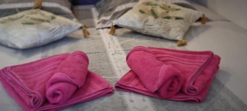 two pink towels sitting on a bed with pillows at Naturiste Port Nature in Cap d'Agde