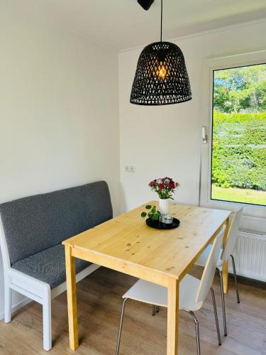 a dining room with a wooden table and a chair at Familie Vakantiehuis - Zonneweelde in Noordwijk aan Zee