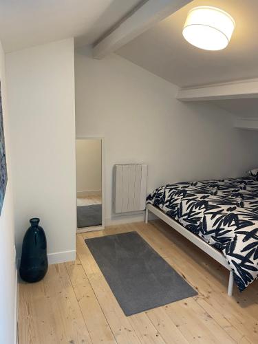 une chambre avec un lit avec une couverture noire et blanche dans l'établissement T3 duplex vue mer, à Aytré