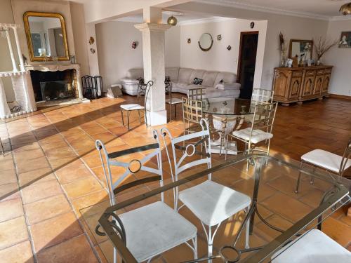 a living room with a glass table and chairs at Villa Prestige, Tennis, Piscine & Spa, Sainte-Baume in Saint-Zacharie