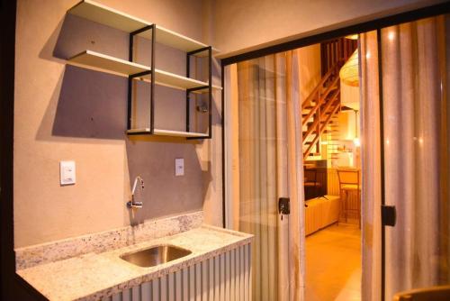 a kitchen with a sink and a mirror at GUARAJUBA TIE 4 Quartos DUPLEX DE LUXO in Camacari