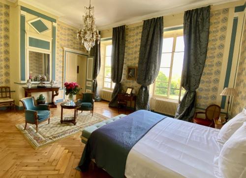 a bedroom with a bed and a table and chairs at Château de la Ferrière in Bayeux