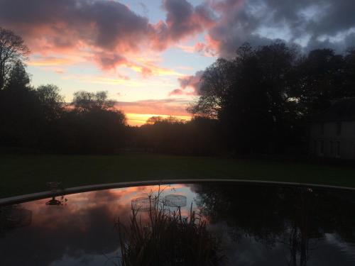 a reflection of a sunset in a pond at Château de la Ferrière in Bayeux