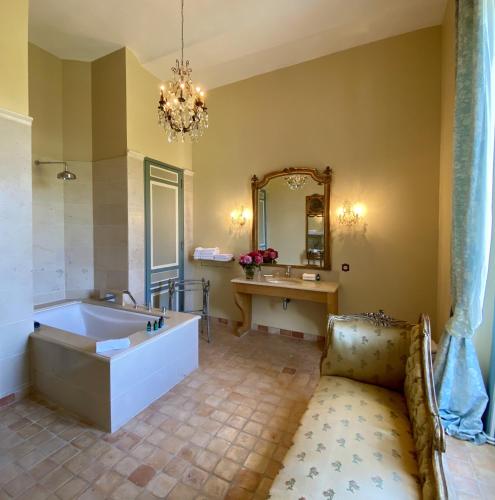 a large bathroom with a tub and a mirror at Château de la Ferrière in Bayeux