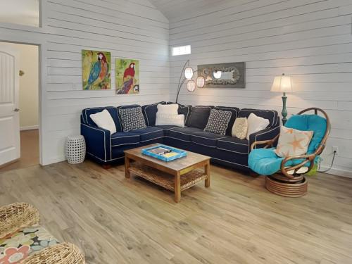 a living room with a blue couch and a table at Jamaica Me Happy in Port Aransas