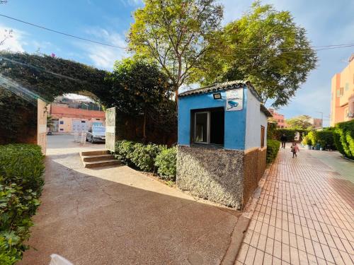 a small blue building on the side of a sidewalk at Julie Airport Marrakech Apartments in Marrakech