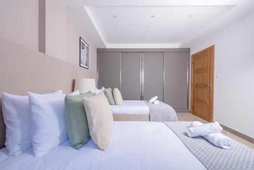 a bedroom with two beds with white pillows at Immense appartement 6pièces au Golf in El Mouradia