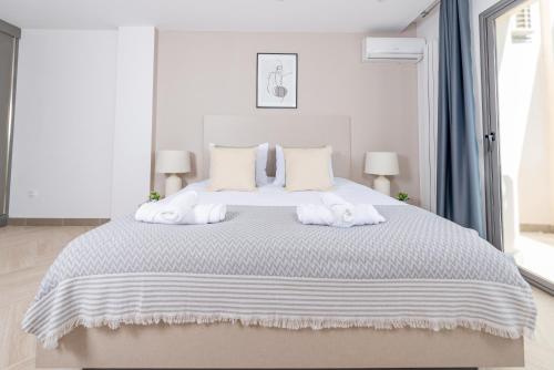 a white bedroom with a large bed with towels on it at Immense appartement 6pièces au Golf in El Mouradia