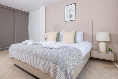 a white bedroom with a large bed with towels on it at Immense appartement 6pièces au Golf in El Mouradia