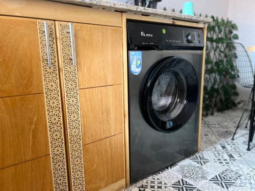 a washing machine sitting inside of a wooden cabinet at Julie Airport Marrakech Apartments in Marrakech