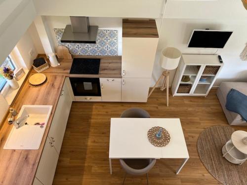 a small living room with a table and a kitchen at Gemütliches Reetdachhaus in Oesterdeichstrich
