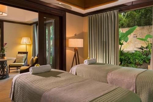 two beds in a hotel room with a window at Just a few minutes walking to the Beach Club in Sabana