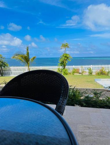 a table and a chair with a view of the ocean at Breeze Brae Home in Grand Turk