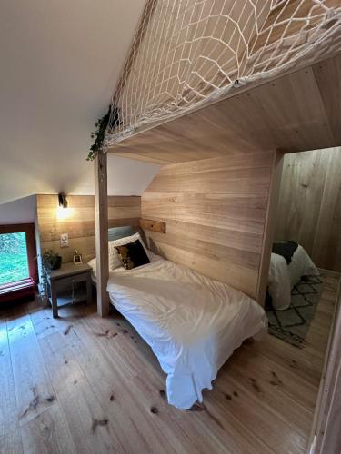 une chambre avec un grand lit avec un mur en bois dans l'établissement La grange de l'Adour Rimoula, à Campan