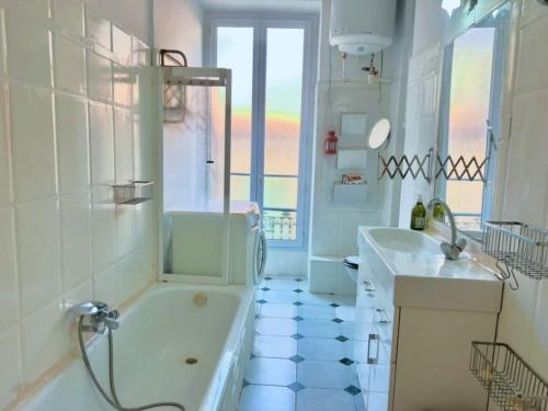 une salle de bain blanche avec une baignoire et un lavabo dans l'établissement 2P proche Jean Médecin, centre ville, à Nice