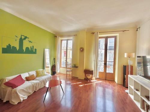 - un salon avec un canapé blanc et des murs verts dans l'établissement 2P proche Jean Médecin, centre ville, à Nice