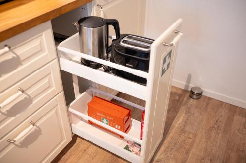 an open kitchen cabinet with a white drawer at Platz für 8 Pers - C4S Come4Stay Monteure "InnArt" Boxspringbett Einzelbett Töging am Inn, Parkplatz, WLAN, Balkon, Smart TV, voll ausgestatteter Küche, Waschmaschine in Töging am Inn