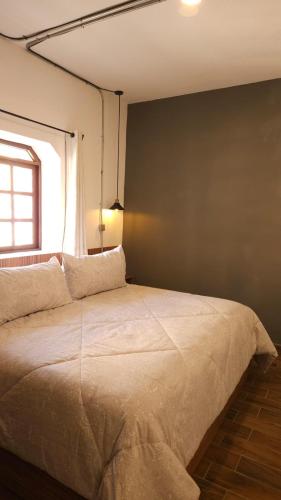 a bedroom with a large bed with a window at Eonia in Atlixco